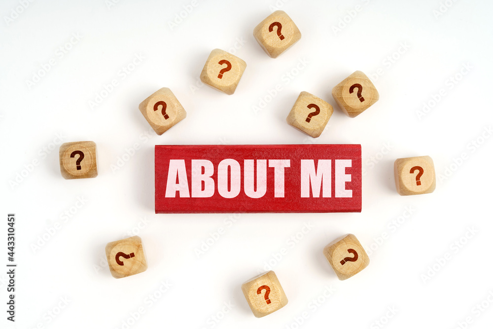 On the table are cubes with questions and a red plaque with the inscription - About Me On the table are cubes with questions and a red plaque with the inscription - About Me