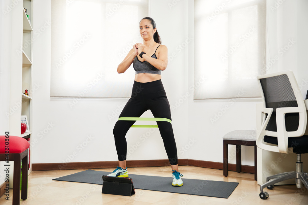 latin woman doing exercise and at home with rubber bands latin woman doing exercise and at home with rubber bands