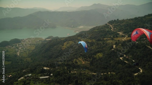 paragliding in the himalayan mountains over a lake