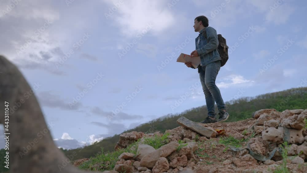 adventurous young man is using a map and compass to navigate the landscape.
adventurous young man is using a map and compass to navigate the landscape.