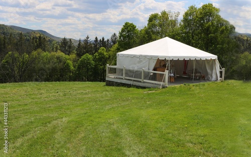 beautiful scenic landscape with an events or entertainment white tent in a grass field © mgs