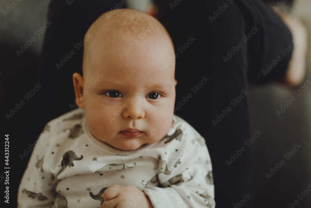 baby lies on daddy's lap