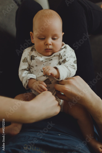 baby lies on daddy's lap