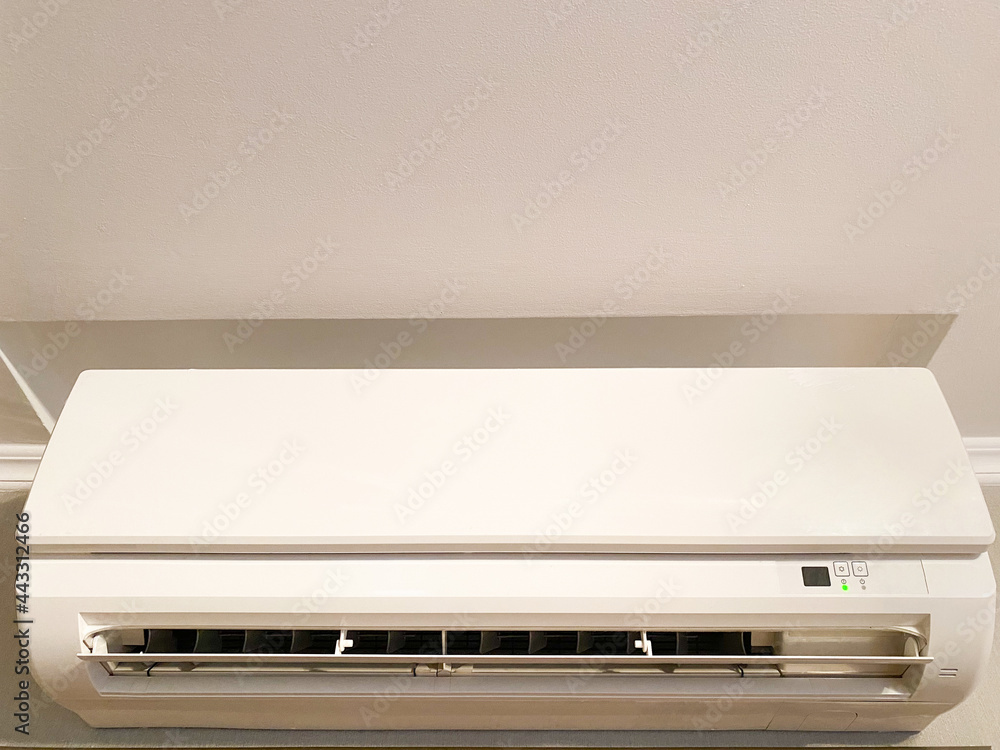 White wall-mounted air conditioner in a house or apartment close-up White wall-mounted air conditioner in a house or apartment close-up
