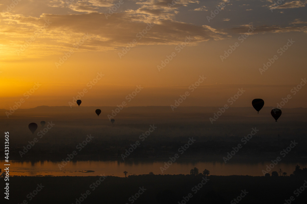 Hot air balloons at sunrise in Luxor, Egypt. The city is covered in the thick morning fog.