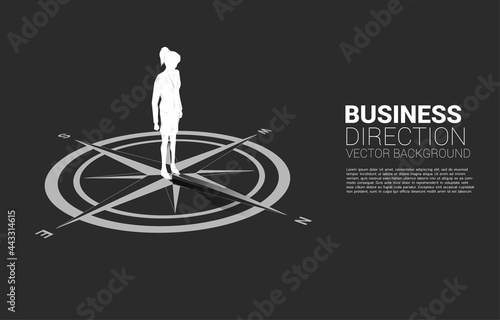 Silhouette of businesswoman standing at center of compass on floor.Concept of career path and business direction