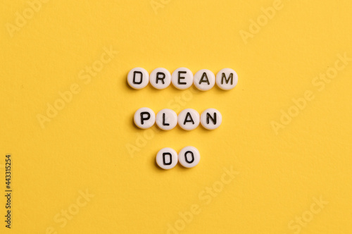 Alphabet letters with text DREAM, PLAN and DO isolated on yellow background