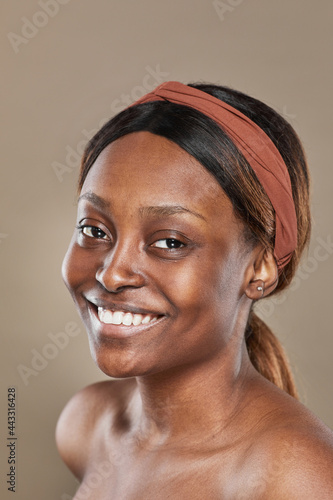 Candid vertical portrait of real African-American woman smiling at camera with no makeup
