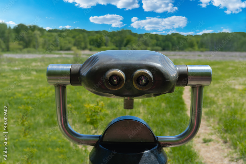 Old viewing scope point green trees grass and blue sky with clouds