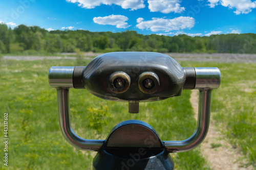 Old viewing scope point green trees grass and blue sky with clouds
