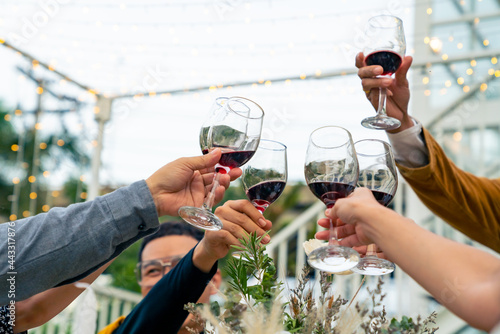 Group of diversity Asian millennial people friends toasting wine glasses while having outdoor dinner party for meeting reunion celebration. Happy friendship enjoy dining and talking together at night