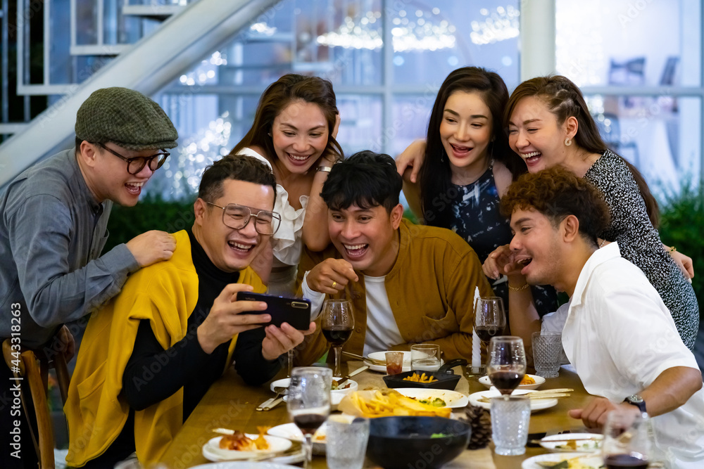 Group of Happy diversity Asian millennial people friends enjoy outdoor dinner party and using smartphone taking selfie together. Reunion friendship meeting celebration party and night life concept.