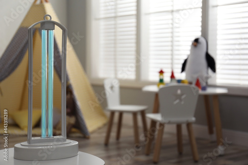 UV sterilizer lamp on table at home. Space for text photo