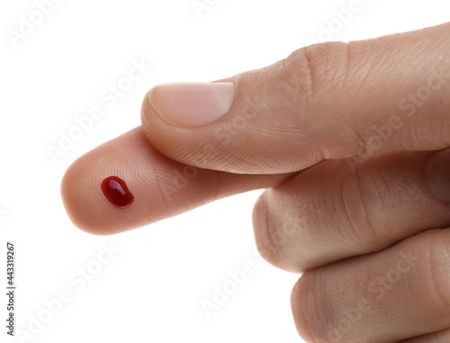 Woman with pricked finger and blood drop on white background, closeup