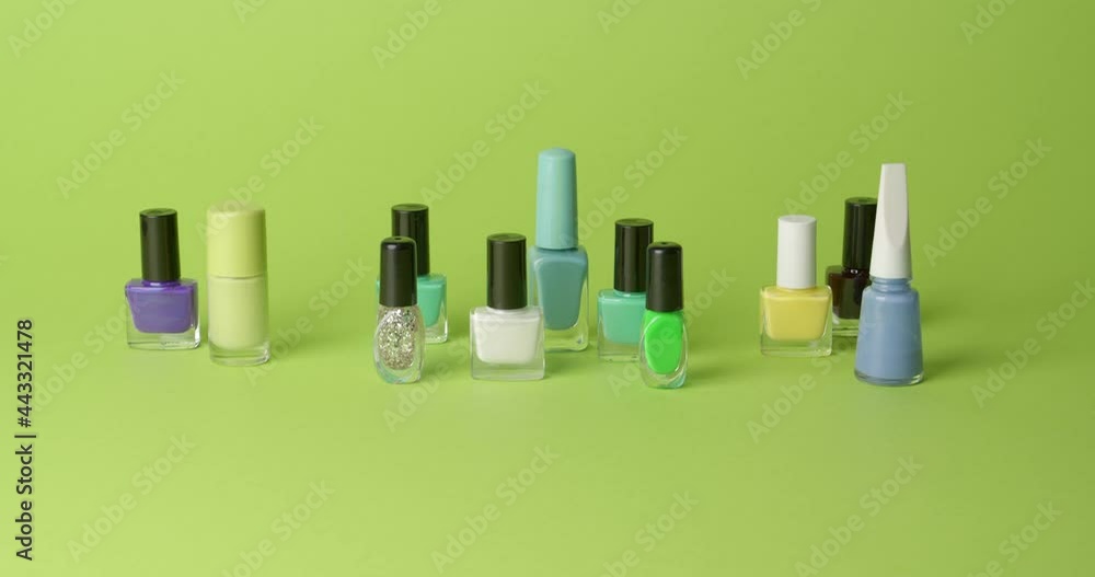 Different nail polishes on color background, video with stop motion effect Different nail polishes on color background, video with stop motion effect