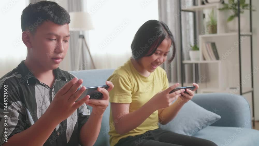 Asian Children Playing Video Games On Mobile Phone And Celebrating Victory At Home
Asian Children Playing Video Games On Mobile Phone And Celebrating Victory At Home