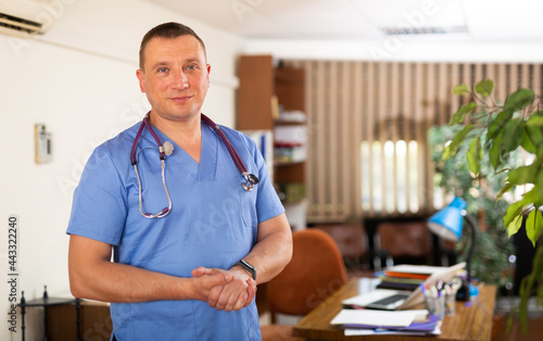 Portrait of confident male doctor standing at medical office