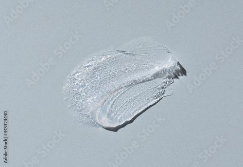 Transparent cosmetic cream on gray background. photo
