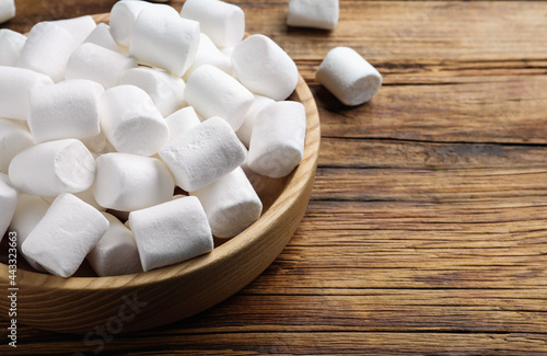 Delicious puffy marshmallows on wooden table, closeup