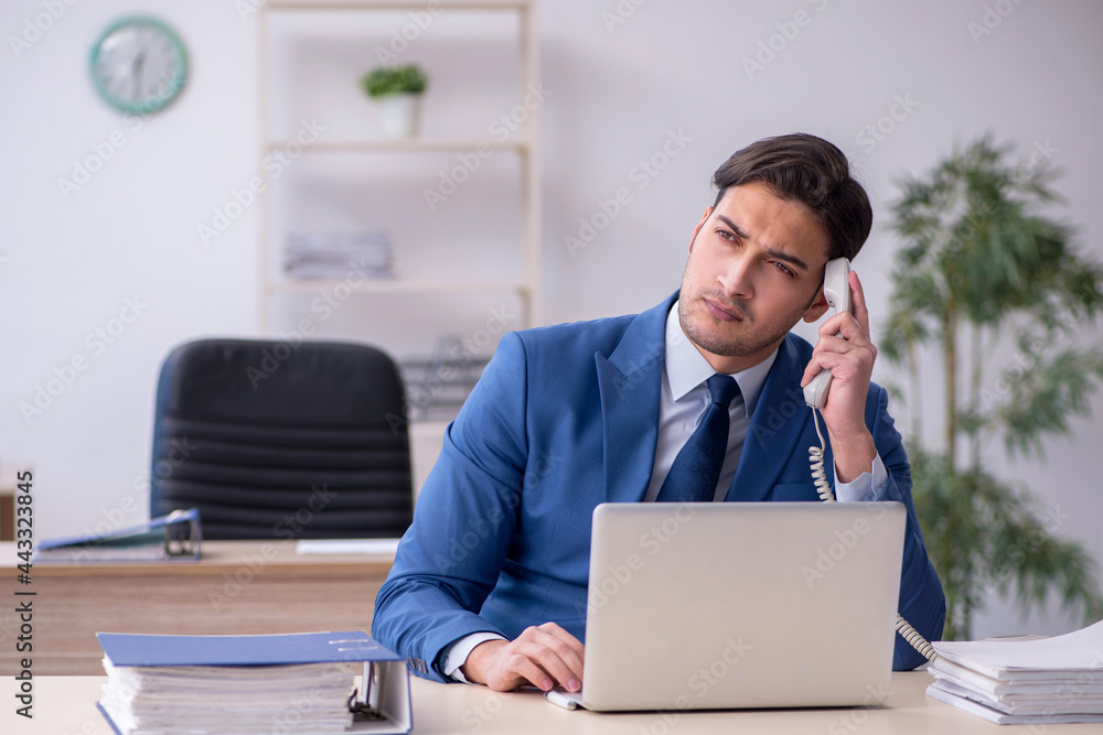 Young male employee sitting in the office Young male employee sitting in the office