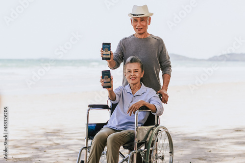 Senior couple display of mobile phone with an approved necessary vaccine certificate for travel. Retired couple shows coronavirus vaccination confirmation.