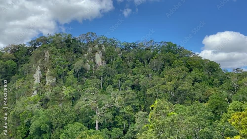 High aerial view flying over rocky escarpments rising up from the Amazon like rain forest jungle, above the dense green canopy, in tropical North Queensland High aerial view flying over rocky escarpments rising up from the Amazon like rain forest jungle, above the dense green canopy, in tropical North Queensland