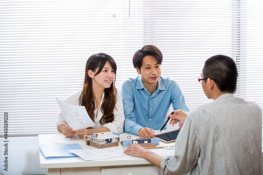 住宅模型を見ながら打ち合わせする施主と設計師 住宅模型を見ながら打ち合わせする施主と設計師