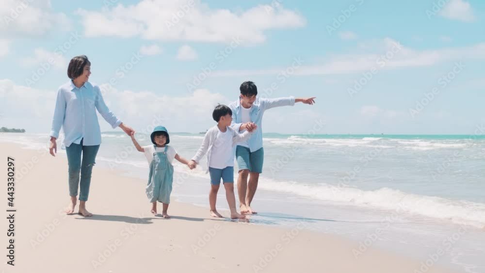Family vacation Parents and children running on the beach Water and clear sky in the morning Family vacation Parents and children running on the beach Water and clear sky in the morning