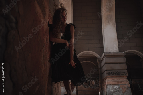 Curly girl in a black dress against the backdrop of the city © Ruslan