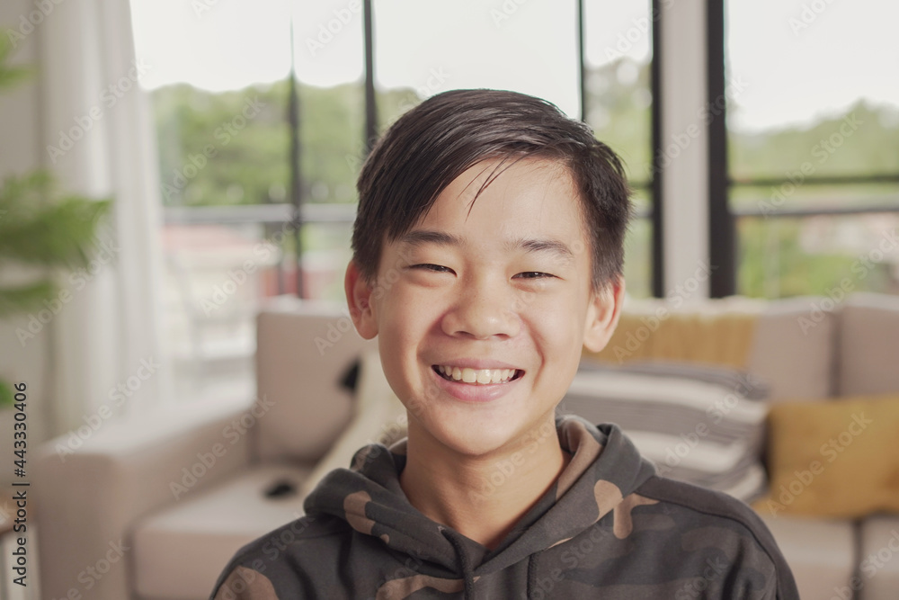 POV Portrait of happy Asian preteen teen boy smiling and making video calling at home, using zoom online virtual class POV Portrait of happy Asian preteen teen boy smiling and making video calling at home, using zoom online virtual class
