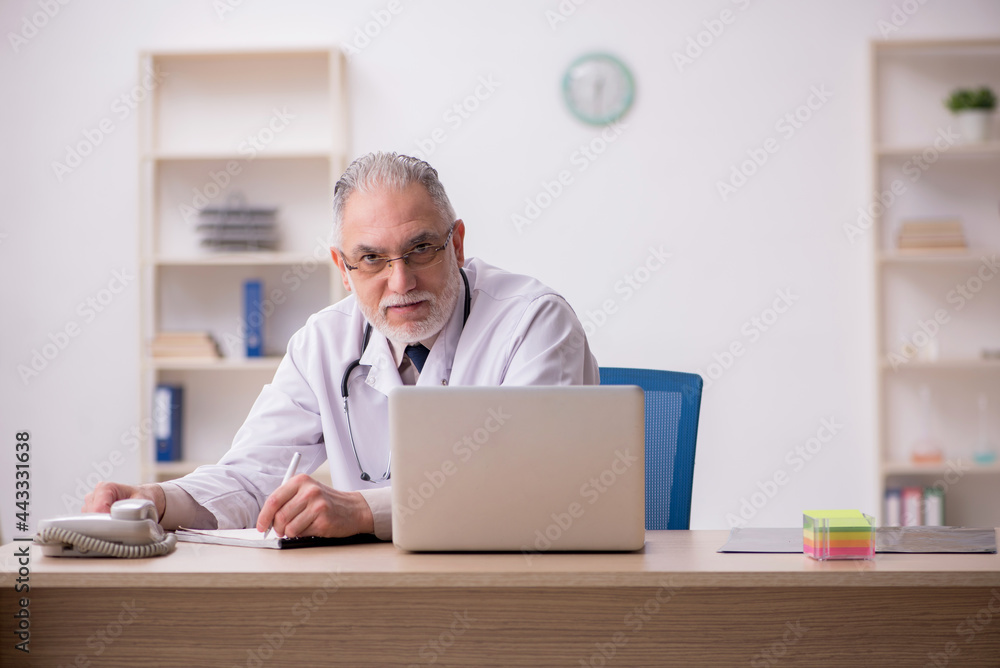 Old male doctor working in the clinic Old male doctor working in the clinic