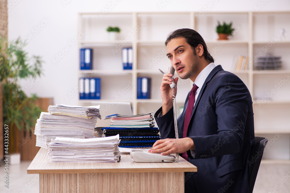 Young male employee unhappy with excessive work Young male employee unhappy with excessive work