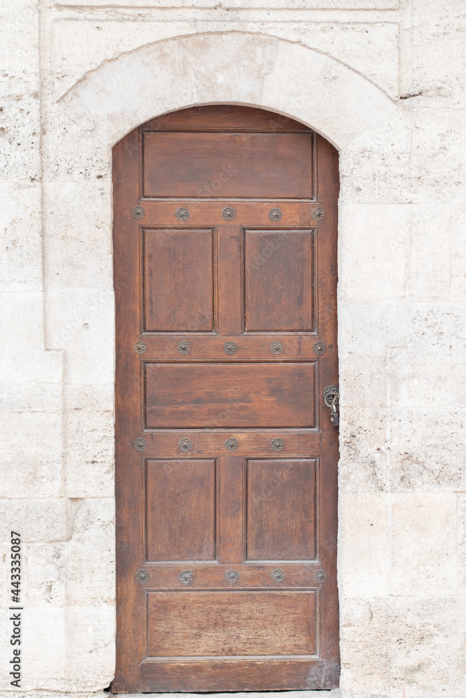 Ancient wooden door in old stone castle wall