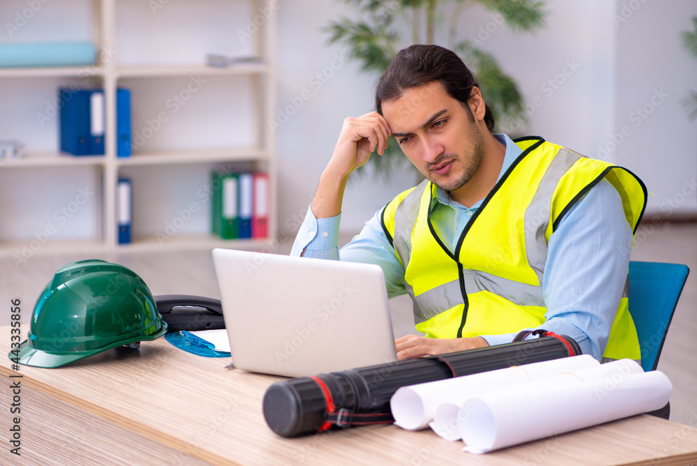 Young male architect working in the office Young male architect working in the office