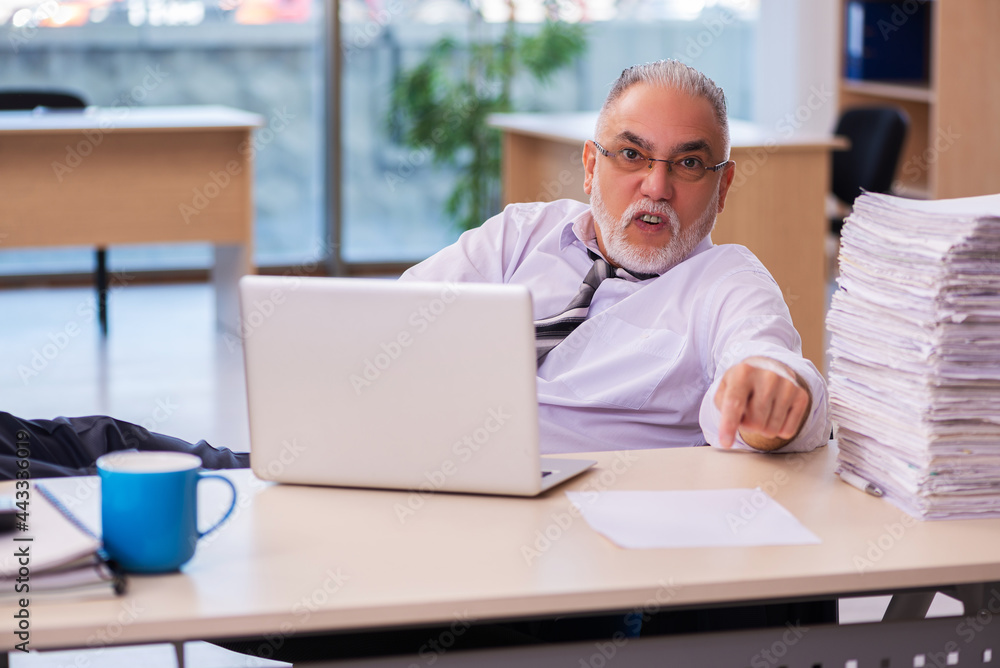 Aged businessman employee unhappy with excessive work Aged businessman employee unhappy with excessive work