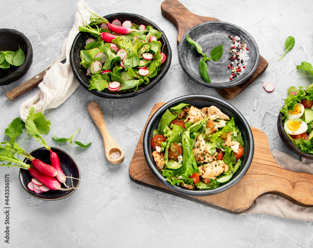 Freshly made salads on light gray background. Seasonal food concept. Freshly made salads on light gray background. Seasonal food concept.