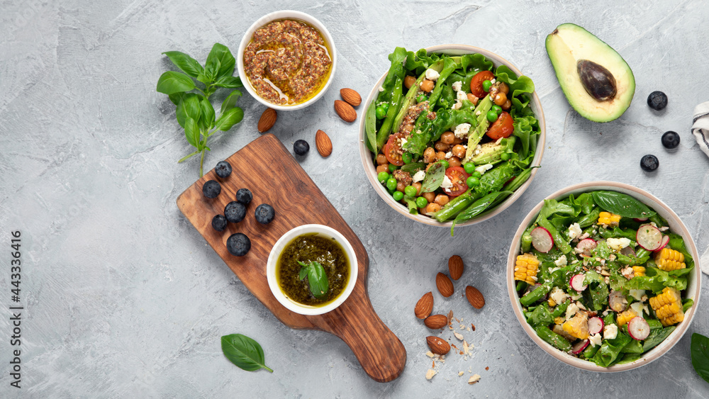 Assorted vegan salads on dark gray background. Seasonal food concept.