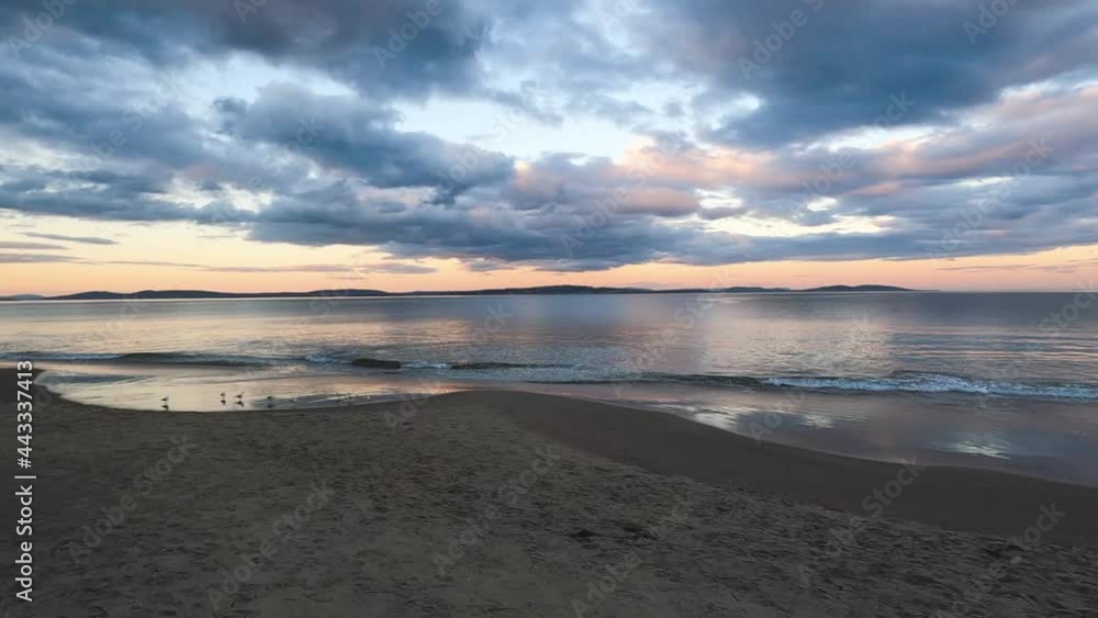 sunset on pristine beach in Southern Tasmania in Australia with colorful clouds reflecting over the Pacific Ocean and no people sunset on pristine beach in Southern Tasmania in Australia with colorful clouds reflecting over the Pacific Ocean and no people