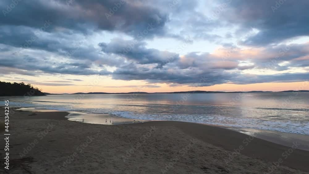 sunset on pristine beach in Southern Tasmania in Australia with colorful clouds reflecting over the Pacific Ocean and no people sunset on pristine beach in Southern Tasmania in Australia with colorful clouds reflecting over the Pacific Ocean and no people