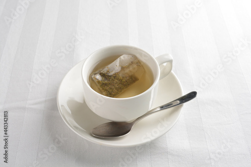 a cup of hot green tea leaf in bag on white background halal beverage menu