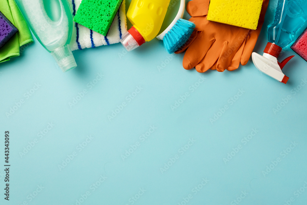 Set of various cleaning supplies on blue background with copy space, top view - obrazy, fototapety, plakaty 
