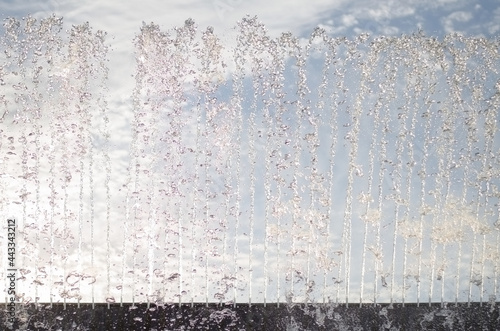 Wall of drops and trickles of water from the fountain rising up
