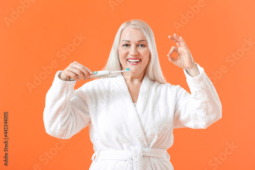Mature woman brushing teeth...