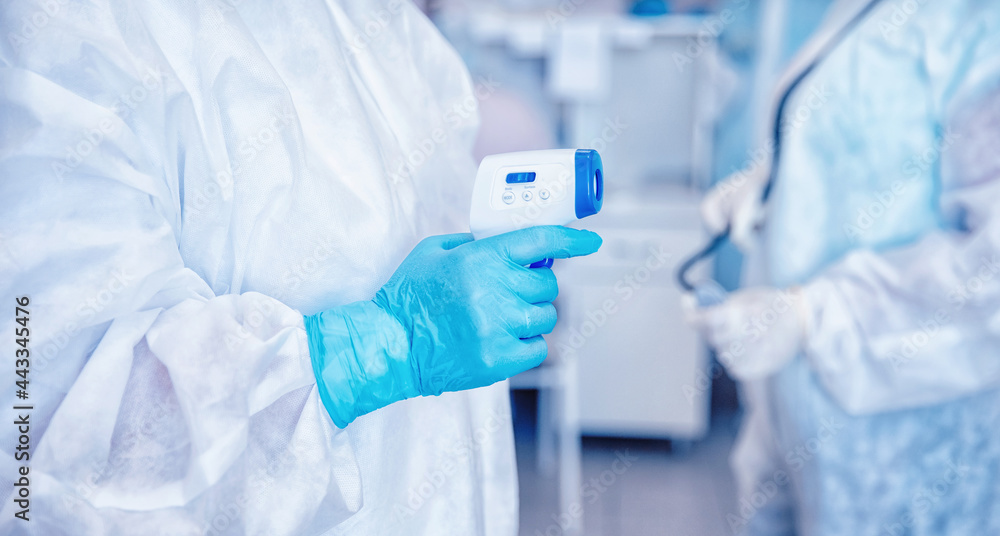 Doctors with thermometer and heart rate monitor check health patient in protective suits and masks in control red area covid19 coronavirus Doctors with thermometer and heart rate monitor check health patient in protective suits and masks in control red area covid19 coronavirus