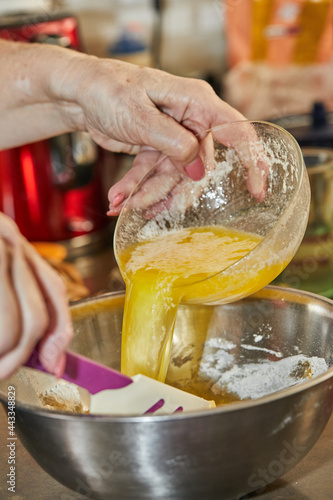 Chef pours the egg yolks into bowl for cherry pie, clafoutis. Step by step recipe