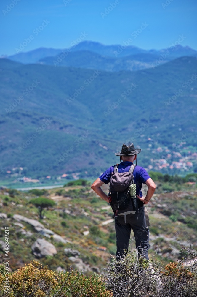 Rear view of senior man with backpack hiking