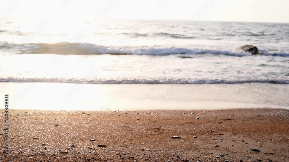 Unpopulated seashore. Waves slowly and calmly run over one another and leave wet trail on gentle sandy shore. Beautiful picture at sunset. Lapping waves. Unpopulated seashore. Waves slowly and calmly run over one another and leave wet trail on gentle sandy shore. Beautiful picture at sunset. Lapping waves.