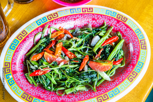 Indonesian food Tumis kangkung or stir fry water spinach served on a plate photo