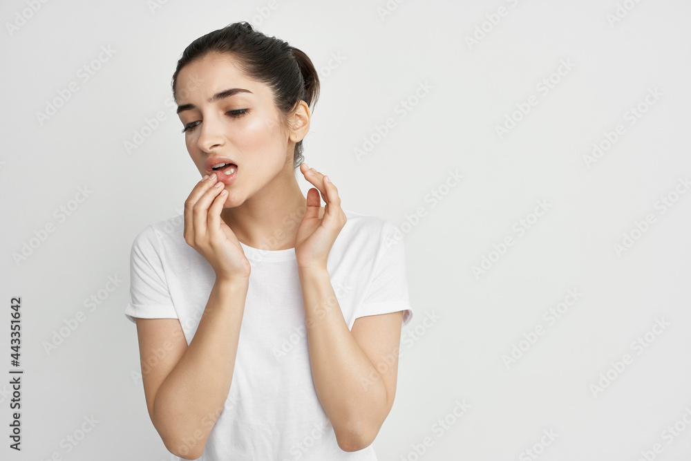 pretty brunette in white t-shirt holding face headache emotion health problems pretty brunette in white t-shirt holding face headache emotion health problems