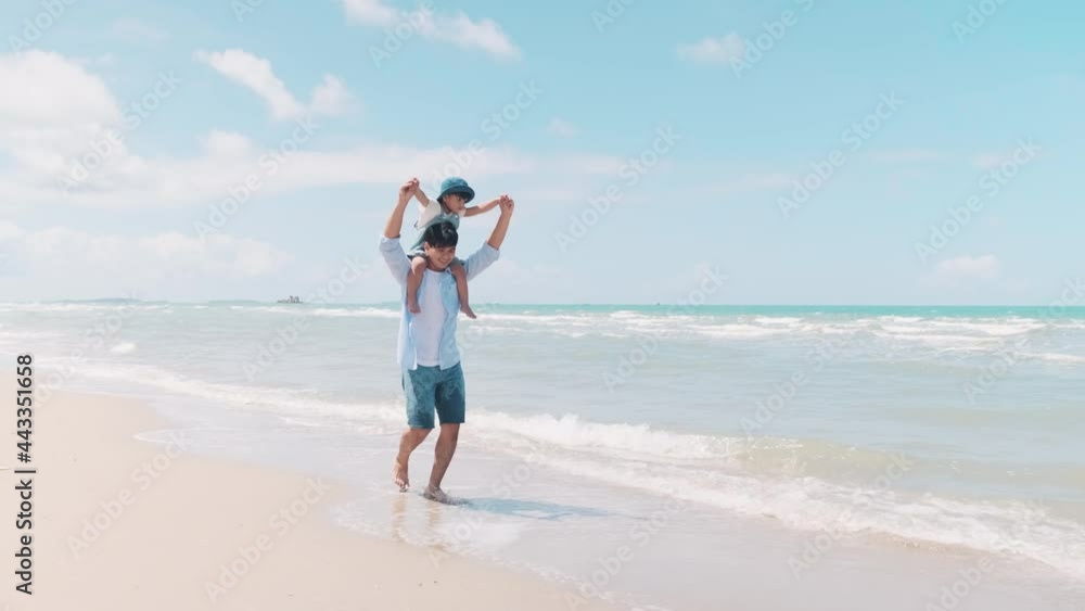 Father and son strolling on the beach happily in the morning sun Father and son strolling on the beach happily in the morning sun